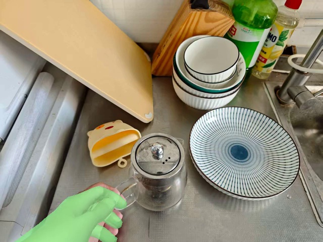 Pour the water from the glass teacup into the plate